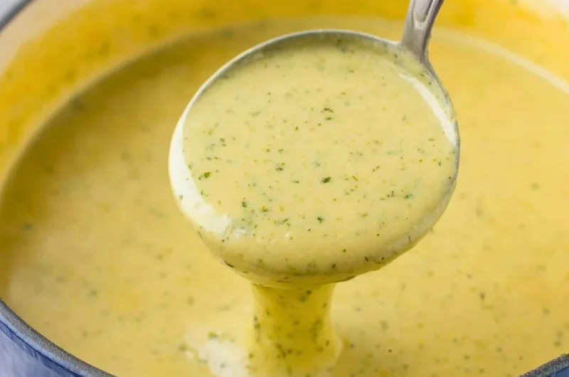 Bowl of creamy zucchini soup topped with herbs and a drizzle of olive oil
