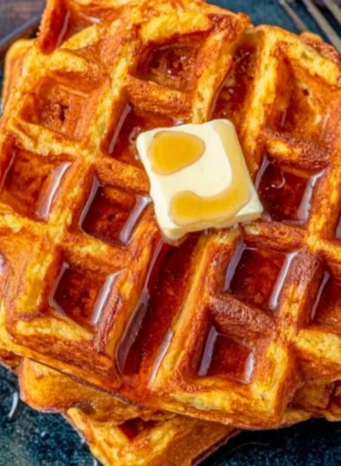 Delicious French Toast Waffles topped with syrup and berries