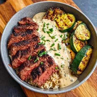Grilled steak bowl with sauce and grilled zucchini served in a bowl