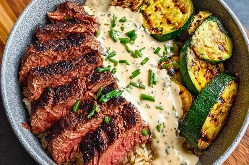 Grilled steak bowl with sauce and grilled zucchini served in a bowl