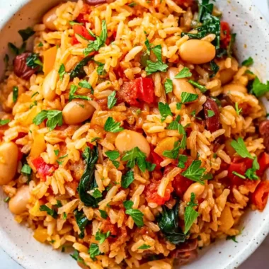 A colorful bowl of Mediterranean Rice and Beans topped with fresh herbs.