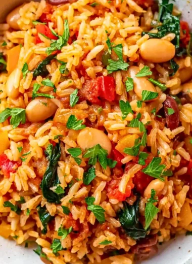 A colorful bowl of Mediterranean Rice and Beans topped with fresh herbs.