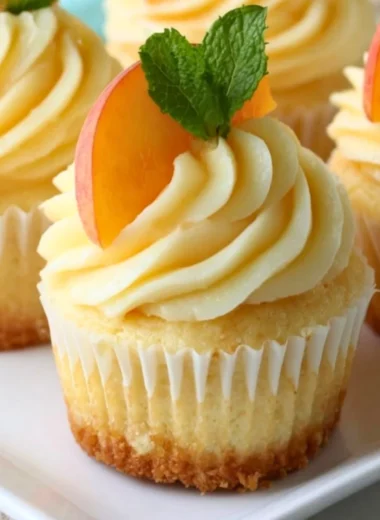 Delicious Peach Honey Cheesecake Cupcakes topped with fresh peaches