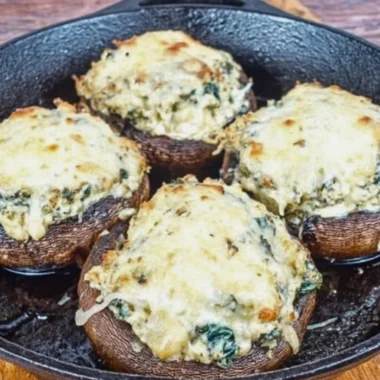 Delicious ricotta stuffed portobello mushrooms on a plate, garnished with herbs.