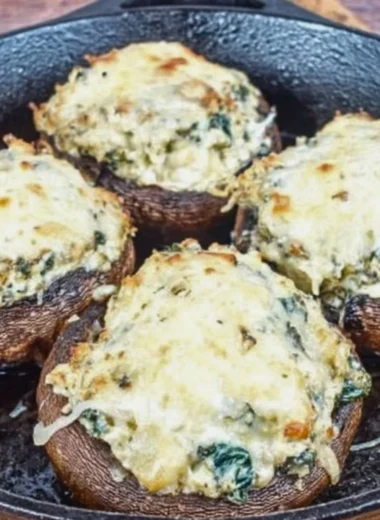 Delicious ricotta stuffed portobello mushrooms on a plate, garnished with herbs.