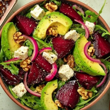 Roasted beet arugula salad with feta cheese and walnuts on a plate