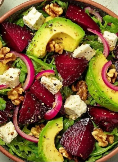 Roasted beet arugula salad with feta cheese and walnuts on a plate
