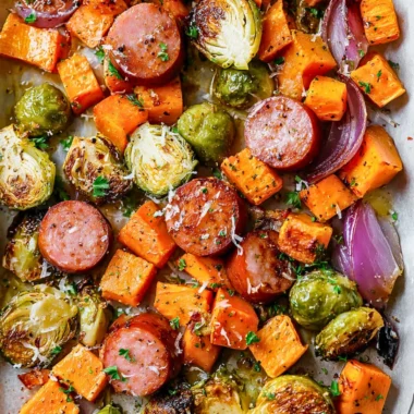 Sheet-pan sausage with vibrant fall vegetables ready to bake.