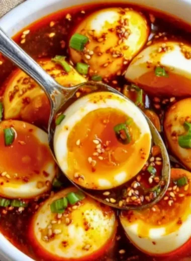 Plate of spicy gochujang eggs garnished with green onions and sesame seeds