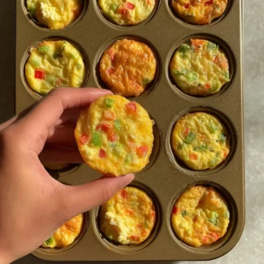 Delicious breakfast egg muffins served on a plate with herbs and vegetables.