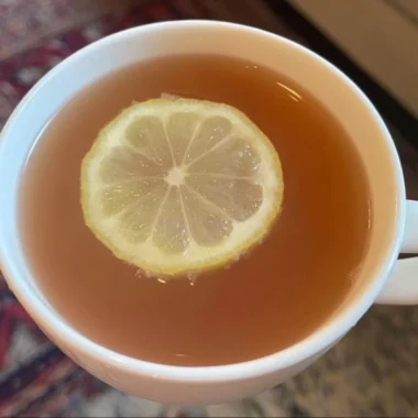 Glass of refreshing Citrus Mint Peach Tea with mint leaves and peach slices