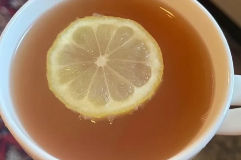 Glass of refreshing Citrus Mint Peach Tea with mint leaves and peach slices