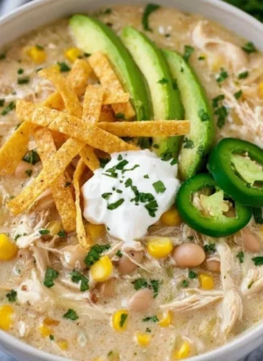 Bowl of creamy white chicken chili topped with cilantro and sour cream