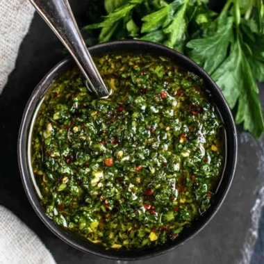 Freshly made chimichurri sauce in a bowl with herbs and spices