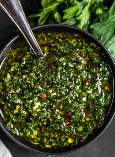 Freshly made chimichurri sauce in a bowl with herbs and spices