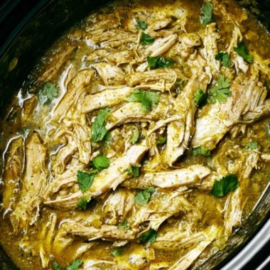 Plate of Green Sauce Crockpot Chicken garnished with fresh herbs