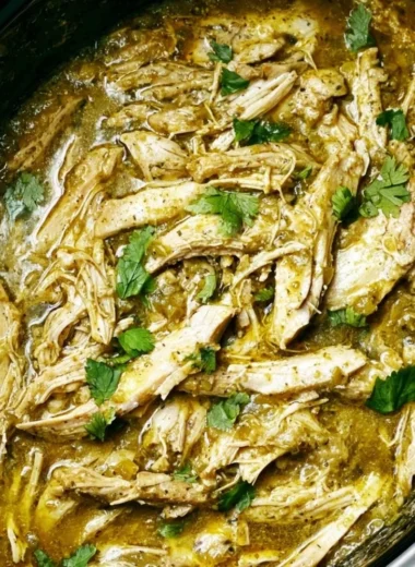 Plate of Green Sauce Crockpot Chicken garnished with fresh herbs