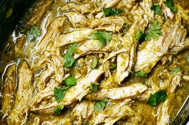 Plate of Green Sauce Crockpot Chicken garnished with fresh herbs