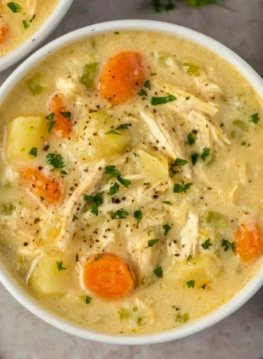 High protein chicken pot pie soup in a bowl garnished with herbs