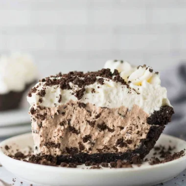 Decadent Oreo Pudding Pie topped with whipped cream and Oreo cookies