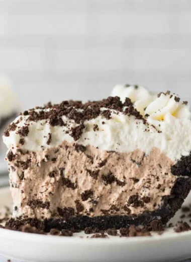 Decadent Oreo Pudding Pie topped with whipped cream and Oreo cookies