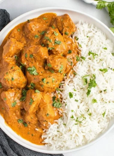 Delicious slow cooker butter chicken served with rice and garnished with cilantro