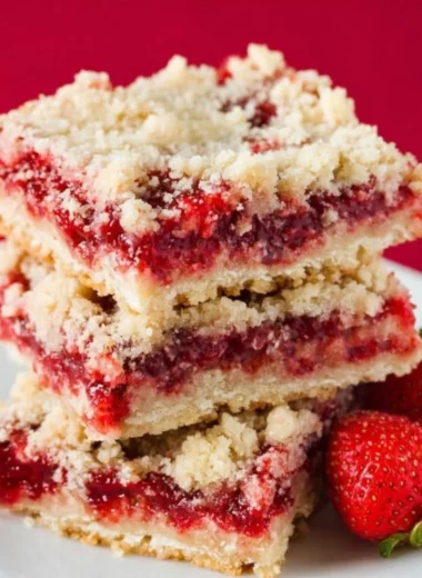 Freshly baked strawberry crumb bars with a golden crumb topping