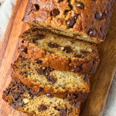 Delicious slice of chocolate chip banana bread on a wooden table