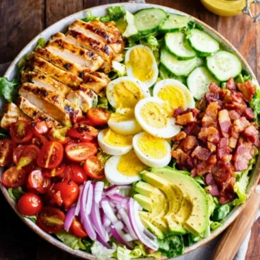Delicious Grilled Chicken Cobb Salad topped with fresh ingredients and dressing.