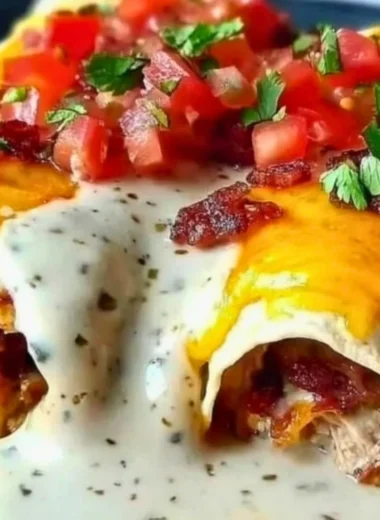 Jalapeño Popper Cheesy Chicken Enchiladas topped with cheese and jalapeños