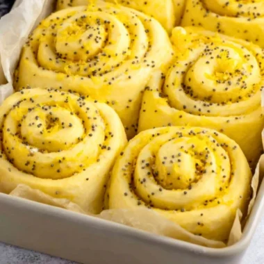 Freshly baked lemon rolls with a citrus glaze on a wooden table