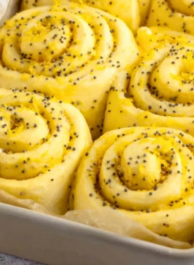 Freshly baked lemon rolls with a citrus glaze on a wooden table