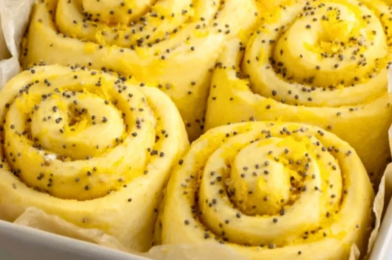 Freshly baked lemon rolls with a citrus glaze on a wooden table