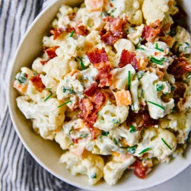 A delicious loaded cauliflower salad topped with fresh vegetables and dressing