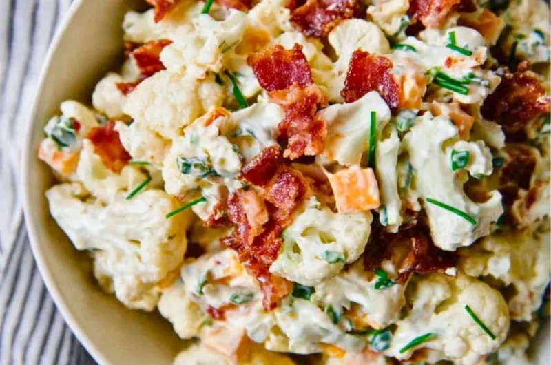 A delicious loaded cauliflower salad topped with fresh vegetables and dressing