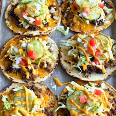 Smashed cheeseburger tacos served on a plate with toppings