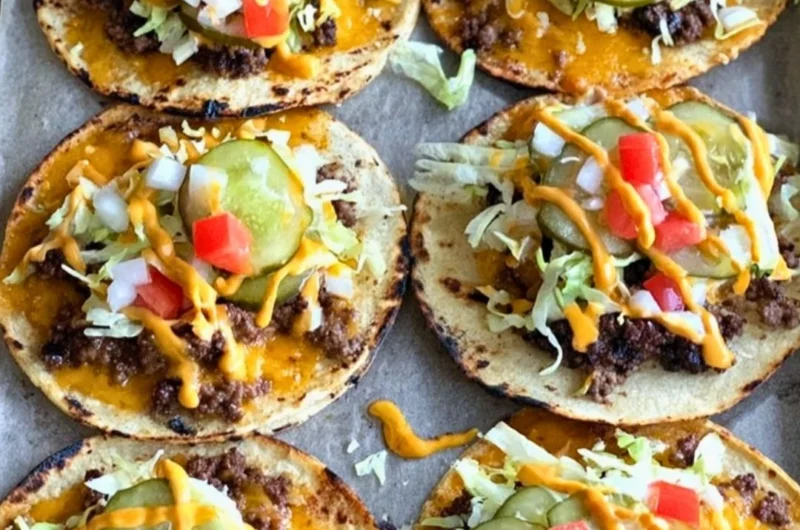 Smashed cheeseburger tacos served on a plate with toppings