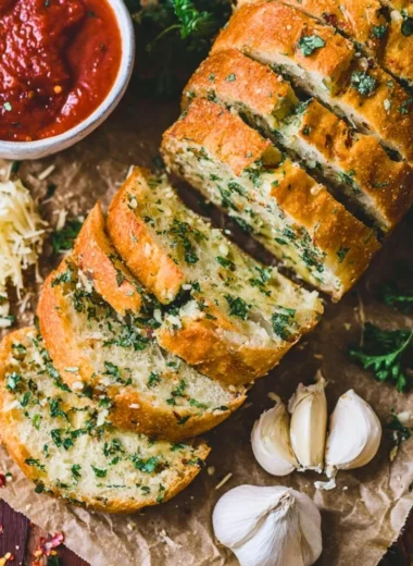 Sourdough garlic bread loaf with golden crust and garlic herb topping