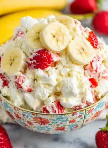 Bowl of Strawberry Banana Fluff Salad with fresh fruits and whipped cream