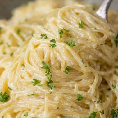 Bowl of creamy garlic parmesan pasta garnished with parsley