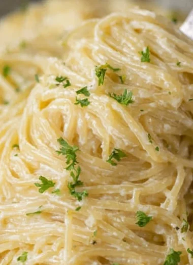 Bowl of creamy garlic parmesan pasta garnished with parsley