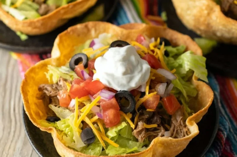 Crispy taco salad bowls filled with fresh ingredients and toppings.