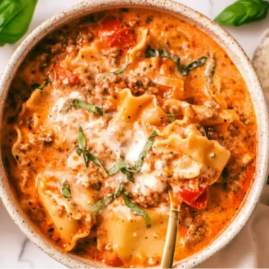 A bowl of creamy lasagna soup garnished with herbs and cheese