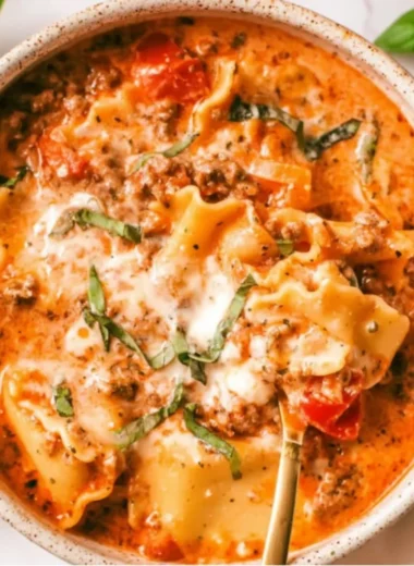 A bowl of creamy lasagna soup garnished with herbs and cheese
