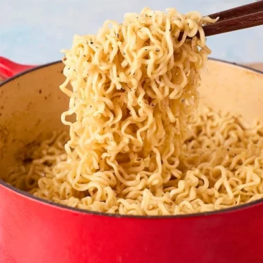 Delicious bowl of garlic butter ramen noodles topped with herbs and spices