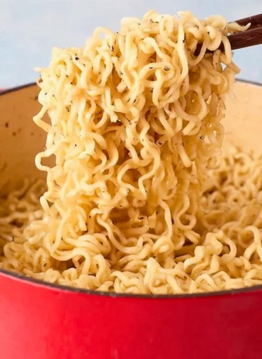 Delicious bowl of garlic butter ramen noodles topped with herbs and spices