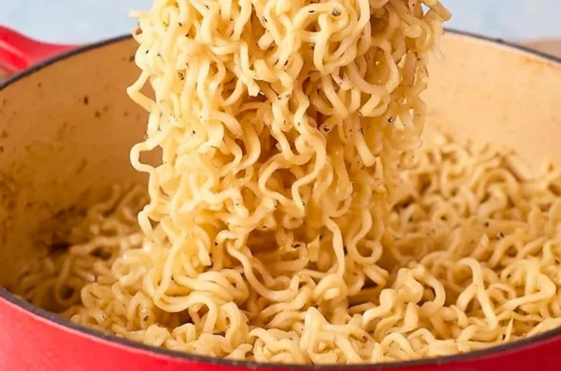 Delicious bowl of garlic butter ramen noodles topped with herbs and spices