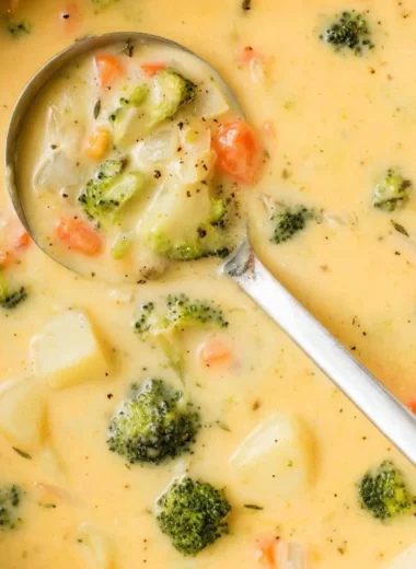 Creamy broccoli cheese potato soup served in a bowl, garnished with herbs.