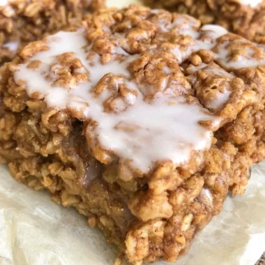 Bowl of healthy cinnamon roll baked oatmeal topped with cinnamon and nuts
