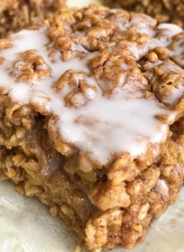 Bowl of healthy cinnamon roll baked oatmeal topped with cinnamon and nuts
